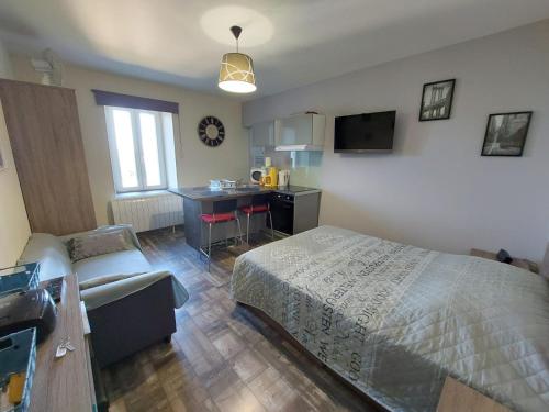 une chambre avec un lit et un bureau et une cuisine dans l'établissement appartement cosy Hôtel Continental, à Vittel