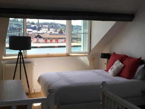 une chambre avec un lit et une grande fenêtre dans l'établissement Le gîte du Petit Matelot, à Fécamp