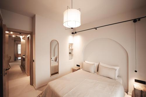a bedroom with a white bed and a mirror at Om Living Afitos in Afitos