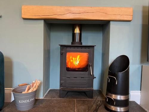 a wood stove with a fire inside of it at Hackney House in Richmond