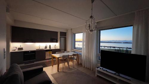 sala de estar con mesa y ventana grande en Uusi upea asunto järvinäköalalla ja autohallilla en Tampere