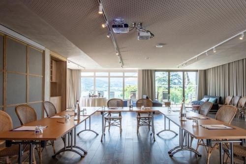 una grande sala da pranzo con tavoli e sedie in una stanza di Hôtel Beau Site Talloires B SPA a Talloires