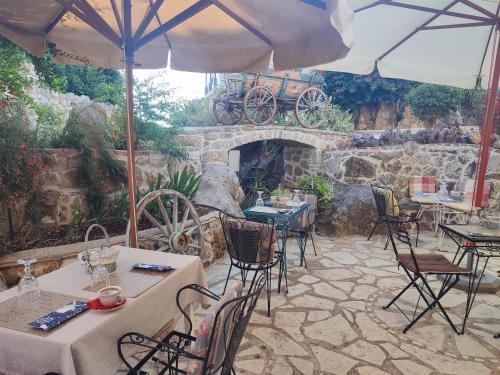 a patio with tables and chairs and a stone fireplace at Archontiko Art Hotel in Galaxidhion