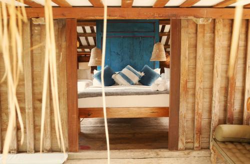 a bedroom with a bed with blue pillows in it at Amar Boutique Hotel in Canggu