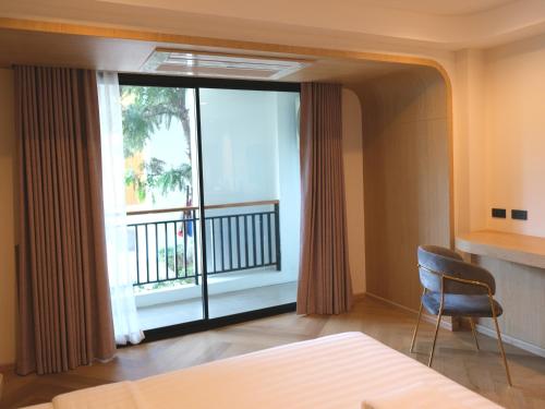 Schlafzimmer mit einem Bett und einem Fenster mit einem Balkon in der Unterkunft Sann Boutique Hotel in Chiang Rai