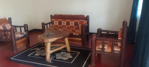 a room with two beds and a table and a stool at Dream jet suites in Entebbe