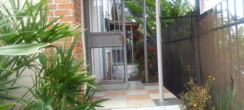 an open door into a courtyard with plants at Dream jet suites in Entebbe