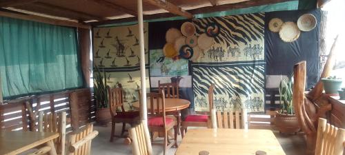 a dining room with a table and chairs and curtains at Dream jet suites in Entebbe