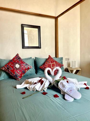 a bed with red hearts and towels on it at Corallini Luxury Apartments - Bokè Apartment in Cervo