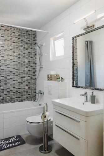 a white bathroom with a toilet and a sink at FrAn in Slavonski Brod