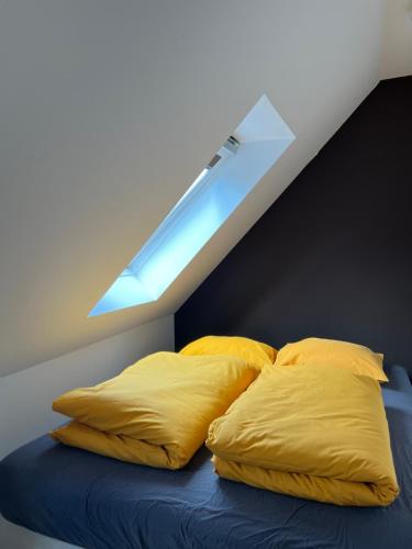 1 cama con almohadas amarillas en una habitación con ventana en Sova, en HoÅ¡Å¥ka