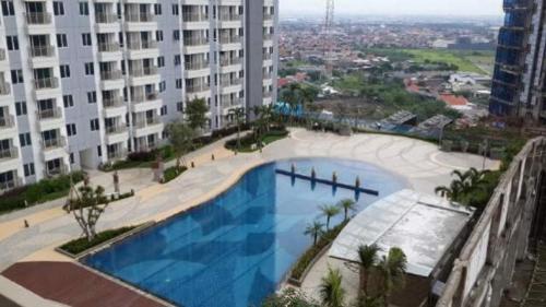 a large swimming pool in the middle of a building at Cosmy Tanglin Apartment in Surabaya