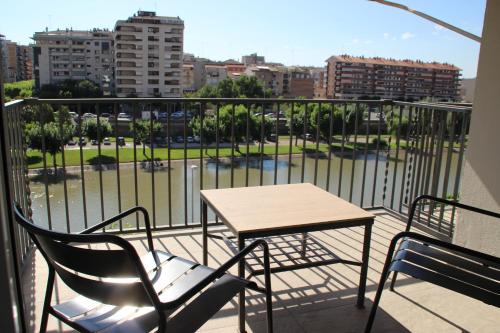 a balcony with a table and chairs and a view of a city at Apartamento completamente reformado en el casco antiguo con vistas al rio in Balaguer