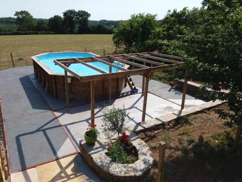 une vue aérienne d'une piscine avec une structure en bois dans l'établissement Domaine de la Garneraie, à Le Champ-Saint-Père