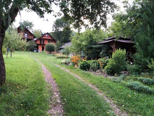 a dirt road in front of a yard with houses at Галіція in Beloberëzka