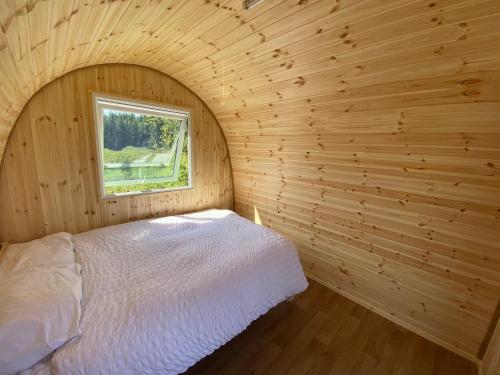 a bedroom with a bed in a wooden room at Lakeside Eco Pod in Oswestry