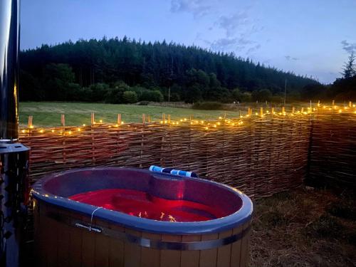 una gran bañera de agua roja en un campo con luces en Roosters Retreat en Launceston