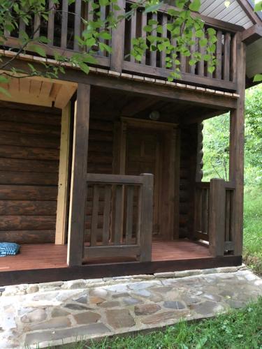 a porch of a log cabin with a deck at Галіція in Beloberëzka