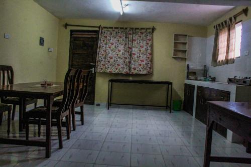 a kitchen with a table and chairs in a room at Armaan Guest House in Diani Beach