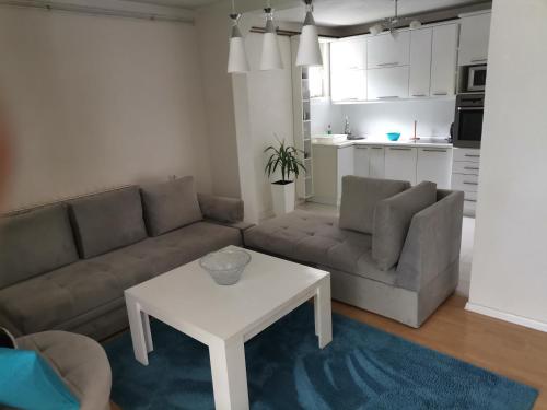 ein Wohnzimmer mit einem Sofa und einem Tisch in der Unterkunft Garden- pool apartman 