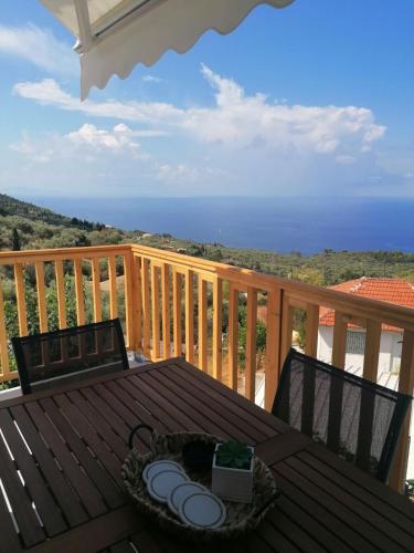a wooden table on a deck with a view of the ocean at Sun Meets Sea in Athanion