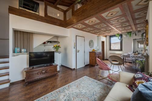 フィレンツェにあるVia Lamberti, 3 - Florence Charming Apartments - Charming and historic 5th-floor attic apartment with elevator in a building at the heart of vibrant Florence, just a 2-minute walk from all attractionsのソファとテレビのあるリビングルーム