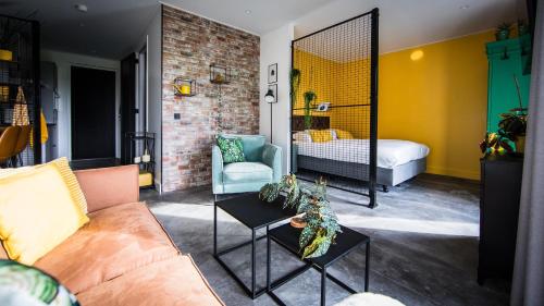 a living room with a couch and a bed and a mirror at Guesthouse Scherp in Middelburg