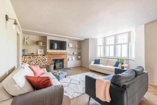 a living room with two couches and a fireplace at Immaculate 6 Bed House with Unique Cellar Bar in Warminster