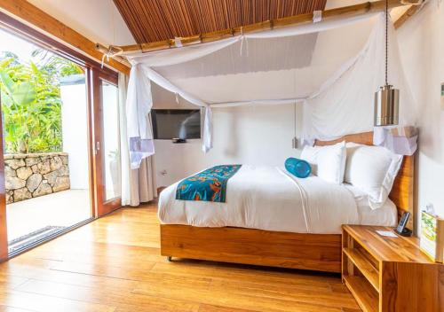 a bedroom with a bed and a large window at Hemingways Retreat Kigali in Kigali