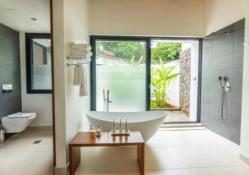 a bathroom with a tub and a shower and a sink at Hemingways Retreat Kigali in Kigali