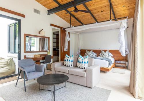 a bedroom with a bed and a couch and a table at Hemingways Retreat Kigali in Kigali