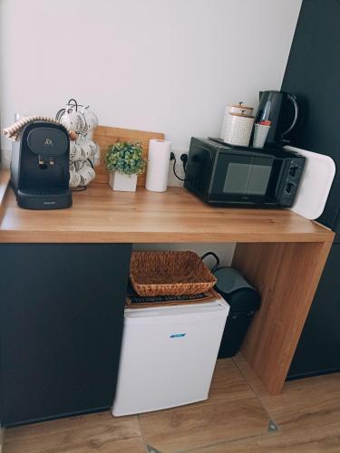 a desk with a microwave and a toaster oven on it at La suite d'Arches in Charleville-Mézières