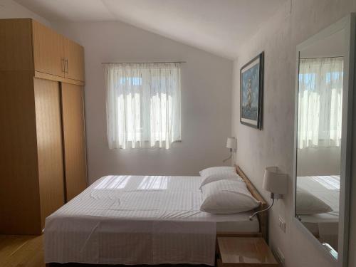 a bedroom with a large white bed with a mirror at Apartment Klara in Krk