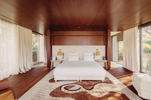 a bedroom with a large white bed and a rug at Lily of the Valley in La Croix-Valmer