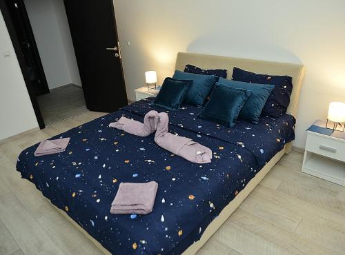 a bedroom with a large bed with a blue comforter at Stan na dan Raška in Raška