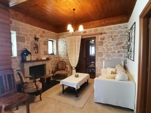 a living room with a white couch and a stone wall at Stonehouse dome Lagadia in Lagkadia