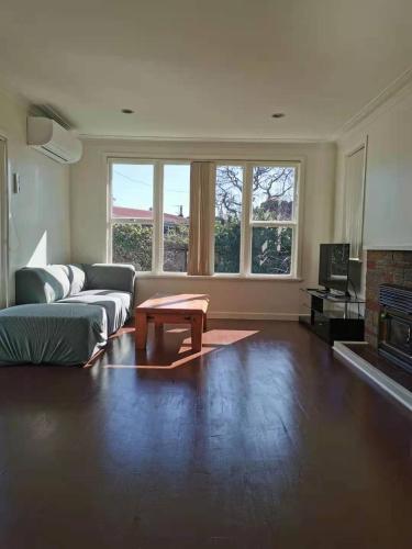 a living room with a couch and a coffee table at White weather board house in Auckland
