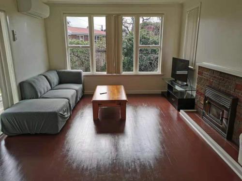 a living room with a couch and a coffee table at White weather board house in Auckland