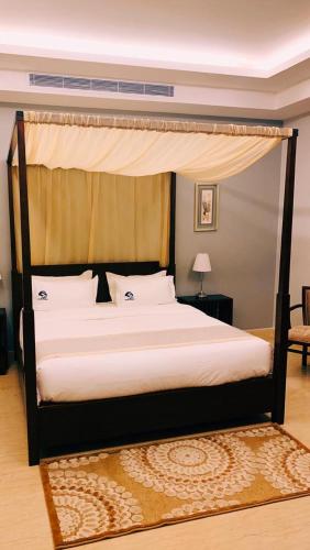a bed in a room with a canopy bed at Hotel & Resort Golden Marina Yanbu in Yanbu