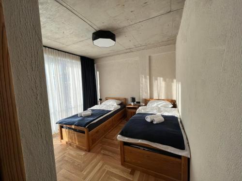 two twin beds in a room with a window at The Pioneers in Chʼkhakoura