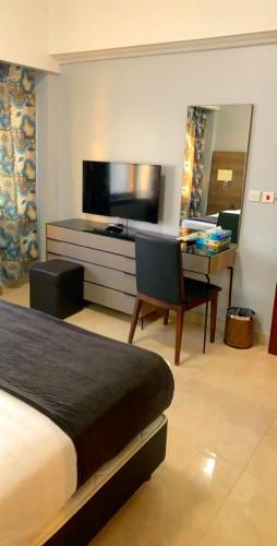 a hotel room with a bed and a desk and a television at Hotel & Resort Golden Marina Yanbu in Yanbu