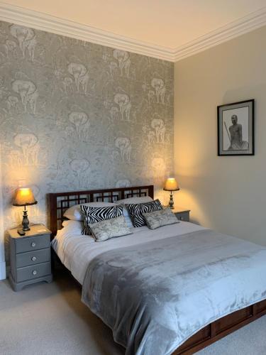 Creity Hall Guest House في Doune: غرفة نوم بسرير كبير ومصباحين