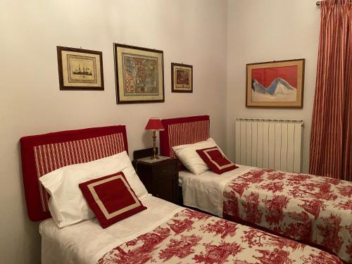 a bedroom with two beds with red and white sheets at A casa di Tina in Mendicino