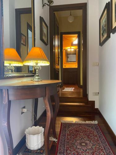 a hallway with a table with a lamp and a mirror at A casa di Tina in Mendicino