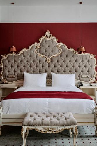 a bedroom with a large bed with a large headboard at Grand Hotel Lviv Casino & Spa in Lviv