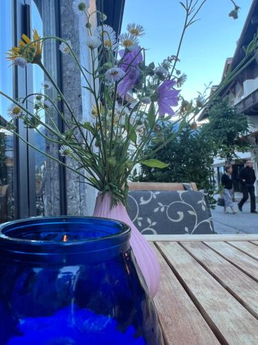a blue vase with flowers in it sitting on a table at Hotel Montana in Sankt Anton am Arlberg
