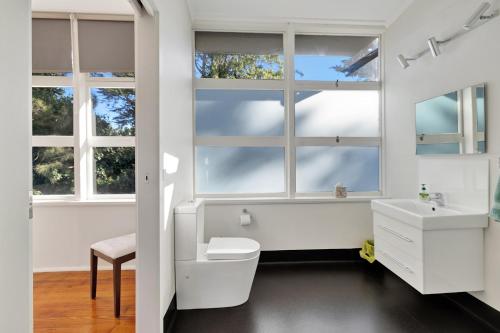 a bathroom with a toilet and a sink and windows at Harmony at Tower Hill in Koroit