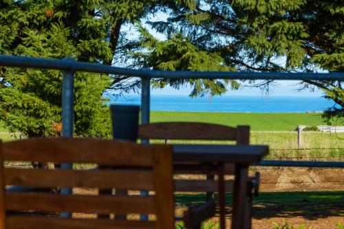 a bench with a table and a view of the ocean at Harmony at Tower Hill in Koroit