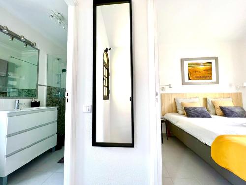 sypialnia z łóżkiem, umywalką i lustrem w obiekcie PAOLA Comfort Apartment w mieście Costa Calma