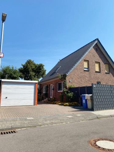 a large brick house with a white garage at Helle Ferienwohnung in Nettetal bei Venlo in Nettetal